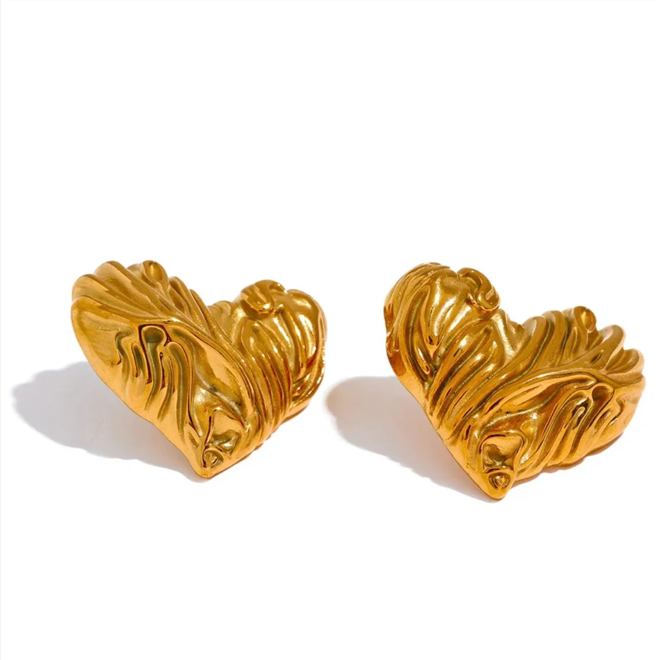 Textured gold heart-shaped earrings on white background