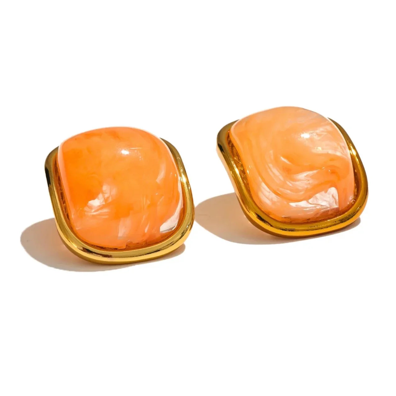 Square orange marbled resin earrings with gold-tone metal trim on a white background