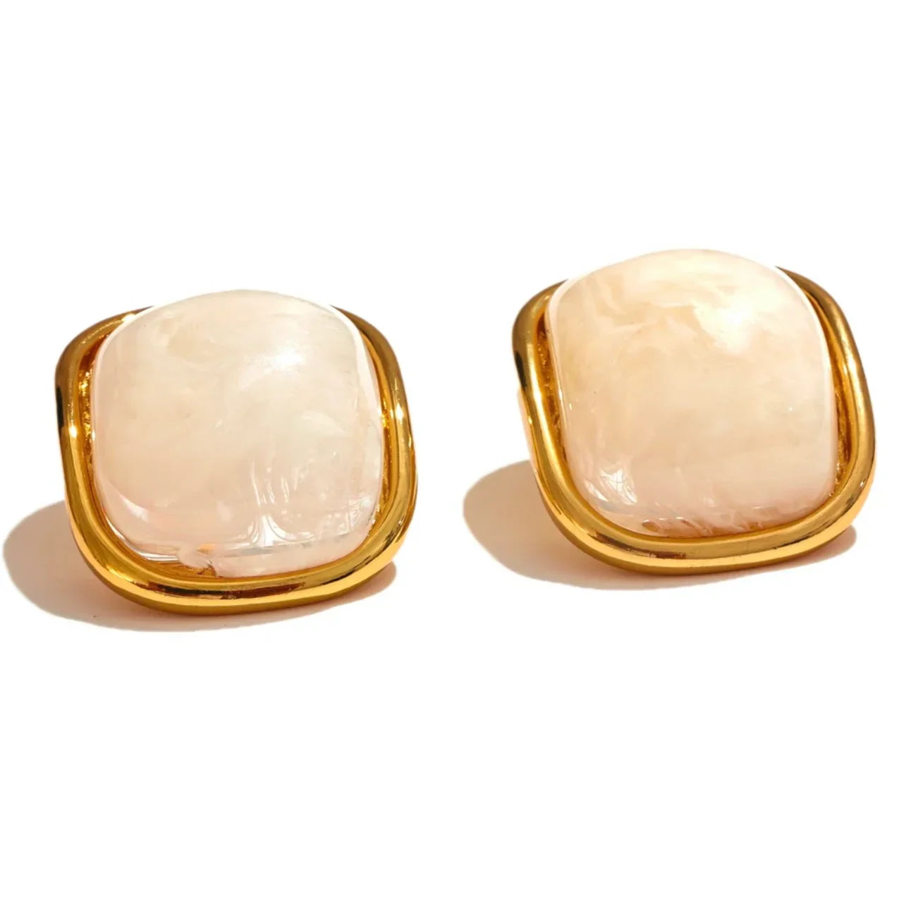 Pair of square gold earrings with polished light pink stone center on white background