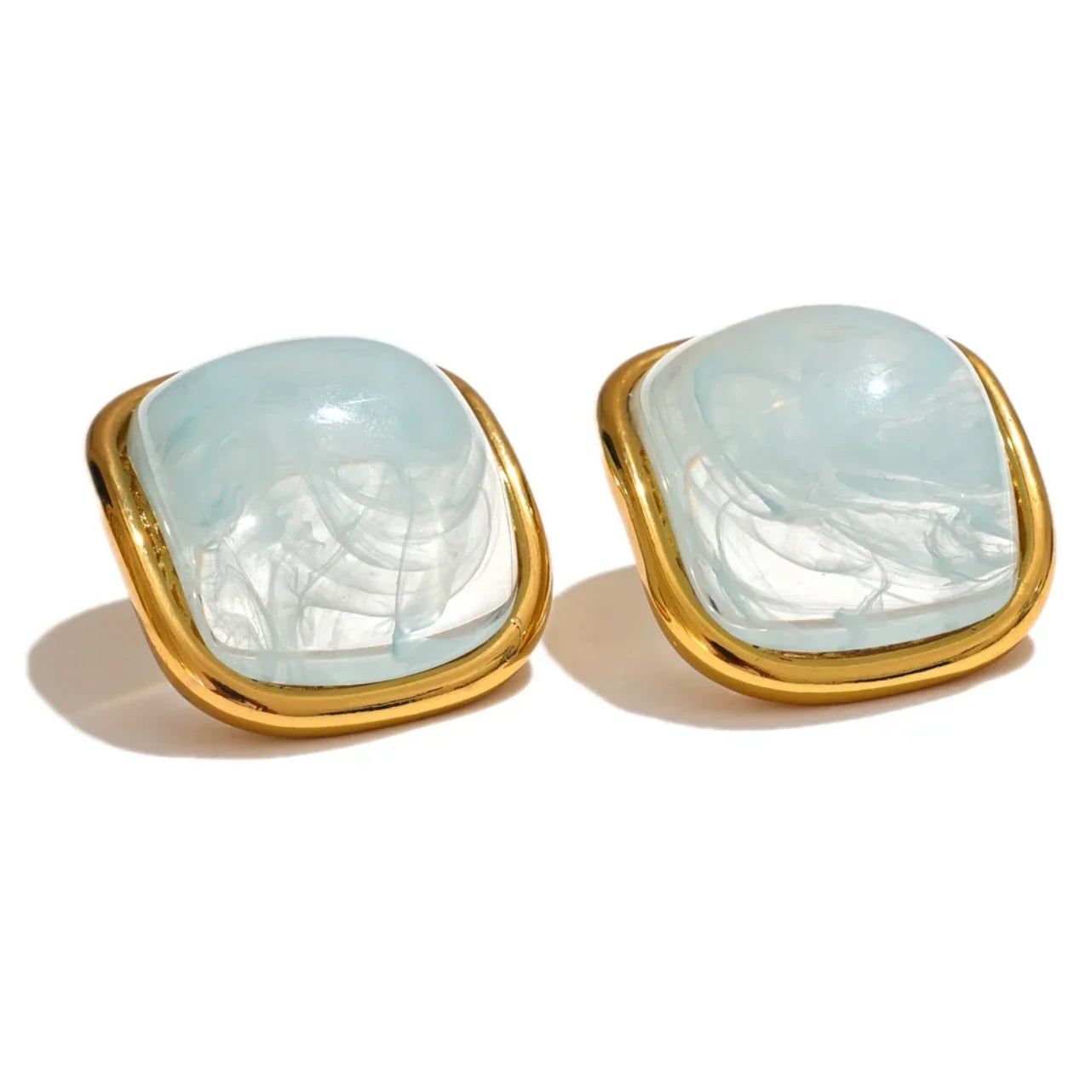 Square gold earrings with light blue marbled glass center on white background
