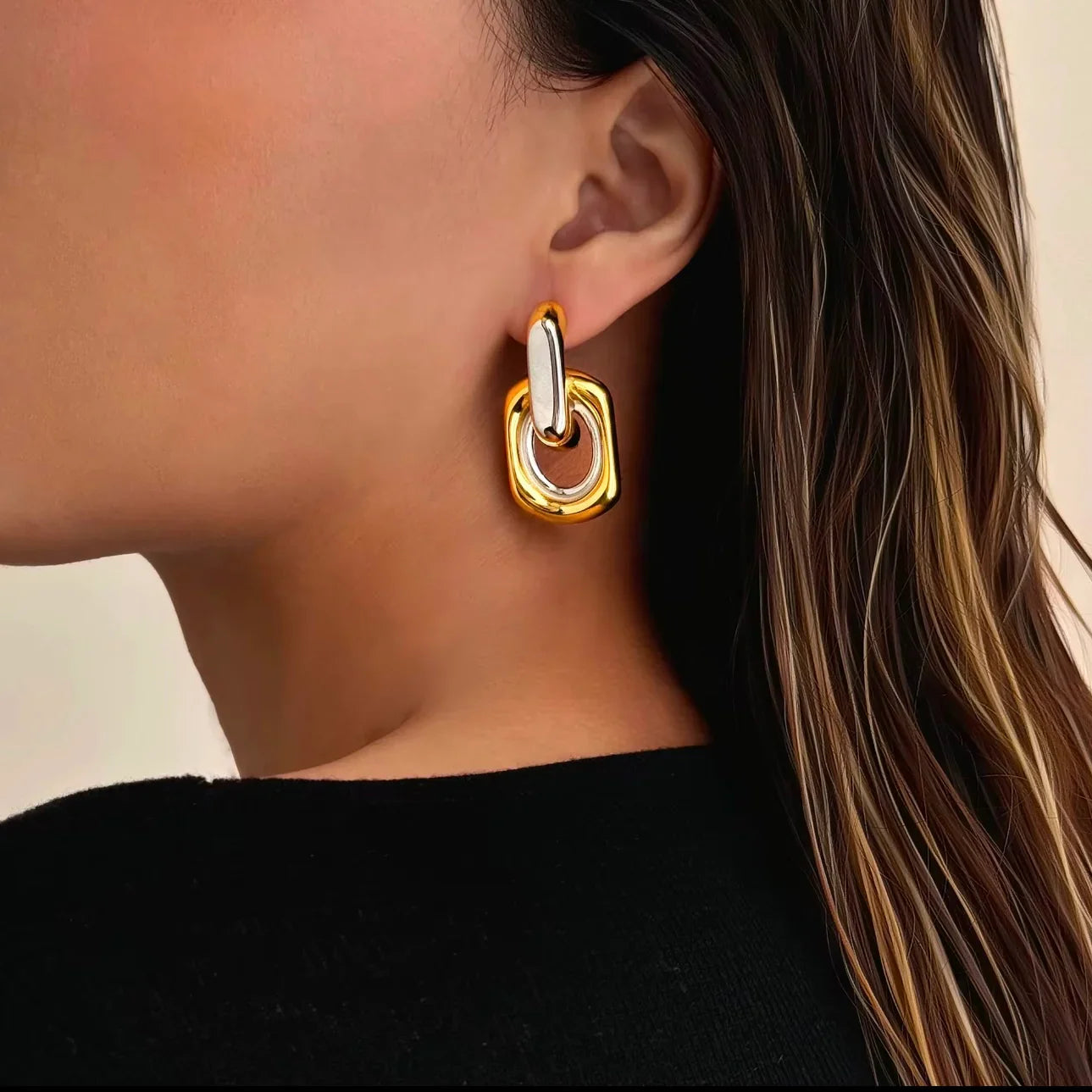 Woman wearing chunky two-tone gold and silver geometric statement earring