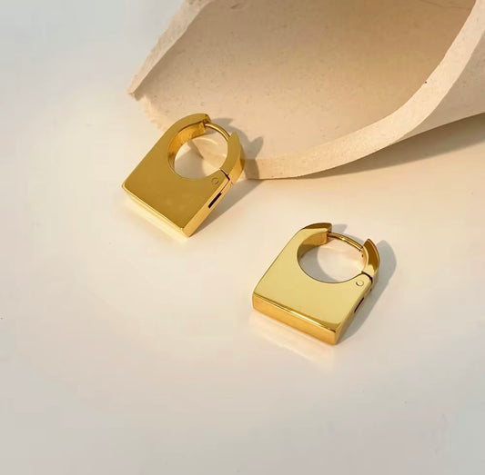 Minimalist gold square hoop earrings on a neutral background